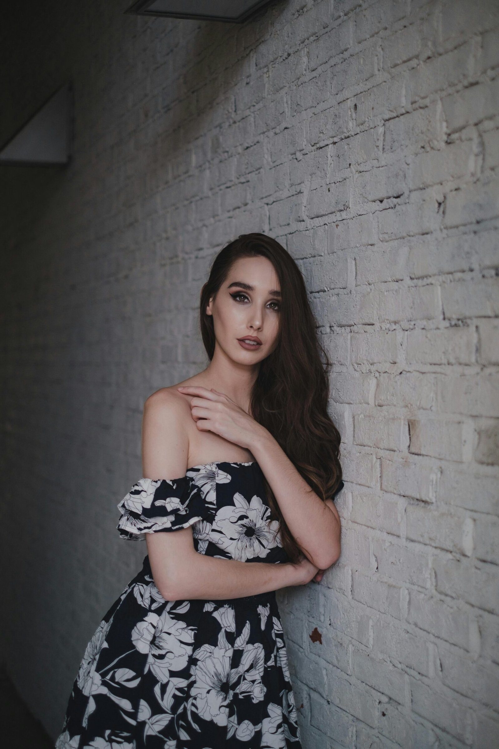 Elegant black and white floral dress with flowing design, paired with minimal accessories for modern fashion look