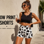 Woman wearing stylish cow print shorts paired with a black crop top, showcasing bold cow print shorts streetwear fashion in a sunny outdoor setting.