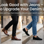 A collage of four stylish footwear options paired with different types of jeans on a city street. From left to right: white leather sneakers with dark blue jeans, brown leather Chelsea boots with black jeans, black suede loafers with cuffed blue jeans, and black high-top sneakers with light-wash jeans. The top of the image features a text overlay that reads: 'Shoes Look Good with Jeans – 15 Best Styles to Upgrade Your Denim Look
