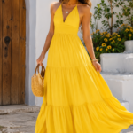 Woman wearing a yellow maxi dress in a sunny outdoor courtyard
